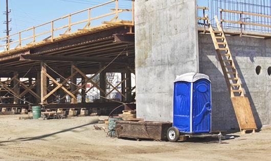 a clean and organized line of porta potties at a job site, keeping workers content